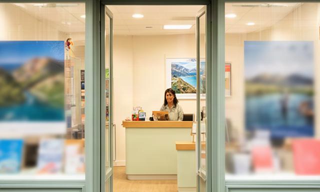 Entrada de una oficina de agencia de viajes en Hendaya con atención cercana y carteles de destinos